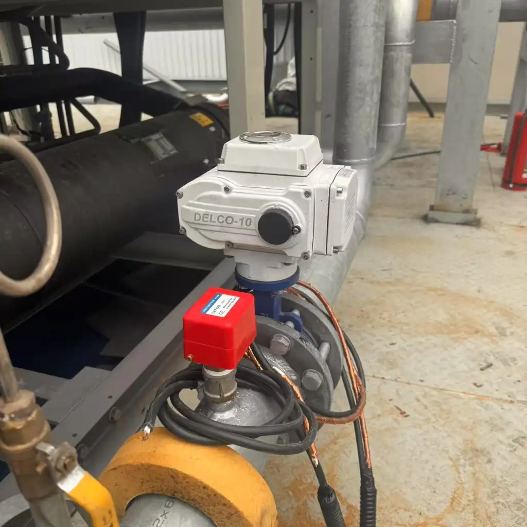 DELCO-10 electric actuated butterfly valve installed on a chilled water pipeline near automated pressure switches.